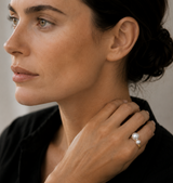 Woman wearing a pearl ring with a blurred background
