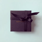 Orfelie jewellery box in black with gold logo, shown on a pale green background