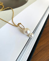 Josephine yellow gold pearl pendant placed on art book