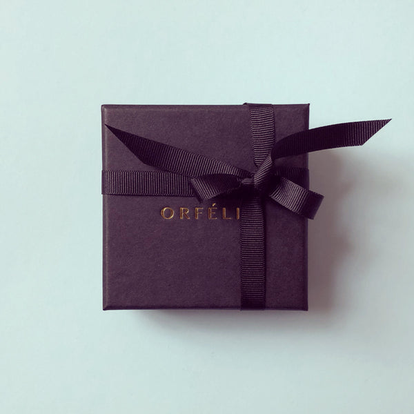 Orfelie jewellery box in black with gold logo, shown on a pale green background